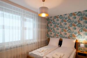 a small bedroom with a bed with a window and a wall at Beskid Apartment in Szczyrk