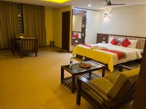 达尔瓦德M R Residency Dharwad.的配有床和沙发的酒店房间