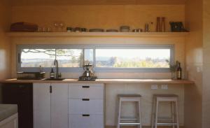una cocina con ventana en una casa pequeña en Southern Highlands Vineyard Cabin by Outpost, en Exeter