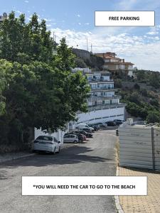 een parkeerplaats met auto's geparkeerd voor een gebouw bij Sesimbra Balcony in Sesimbra
