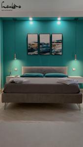 um quarto com uma cama grande com quatro quadros na parede em Leukòs Bed and Breakfast em Castelsaraceno