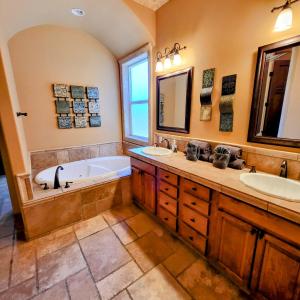 een badkamer met 2 wastafels, een bad en een bad bij Family-friendly Riverfront mansion pool and spa in a calm cove of the Colorado River in Bullhead City