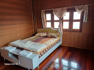 een klein bed in een kamer met een raam bij ริมเมืองโฮมสเตย์ in Phrae