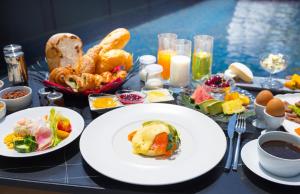 uma mesa coberta com pratos de alimentos e bebidas em ANA InterContinental Appi Kogen Resort, an IHG Hotel em Hachimantai