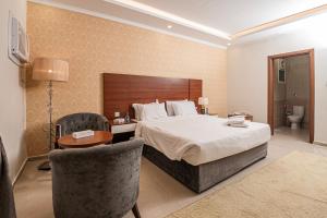 a hotel room with a bed and a table and chairs at فندق غالية احد in Al Madinah