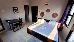 Un dormitorio con una cama y una mesa. en Rumaisa Hotel en Zanzíbar