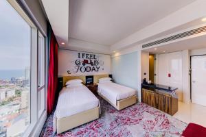 a bedroom with two beds and a large window at Cinnamon Red Colombo in Colombo