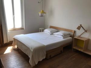 ジュアン・レ・パンにあるオテル デ ラ ピネードのベッドルーム1室(白いシーツとランプ付)