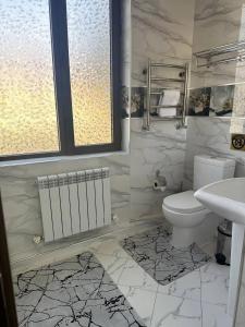 y baño con aseo y lavamanos. en Meros Boutique Hotel, en Tashkent