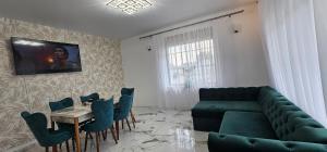- un salon avec un canapé, une table et des chaises dans l'établissement Vila Kalibu, à Piatra Neamţ
