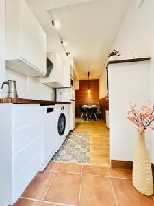 a kitchen with white cabinets and a vase with flowers in it at Nuevo Cosy Loft 4pax Estavar in Estavar