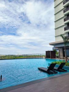 a pool with lounge chairs in front of a building at Wanz Barakah Homestay @ Bali residence in Melaka