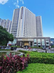 um grande edifício com carros estacionados em frente em The Pavilion Century Tower (Huaqiang NorthBusiness Zone) em Shenzhen