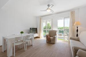 a white living room with a white table and chairs at Casa Mar de frente in Málaga