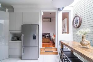 eine Küche mit einem Kühlschrank und einem Holztisch in der Unterkunft The Young - A Peaceful Parkside Delight in Sydney