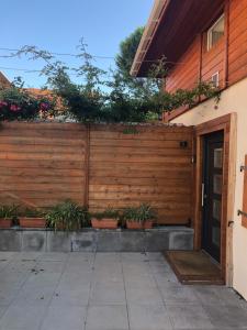 una recinzione di legno con piante in vaso accanto a una porta di cocooning a Rumersheim-le-Haut