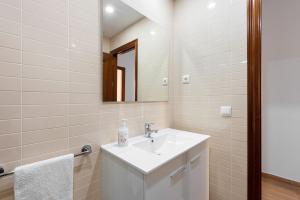 Baño blanco con lavabo y espejo en Casa Mar de frente en Málaga