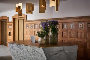 uma mesa com um laptop e flores sobre ele em Hotel GRACE LA MARGNA ST MORITZ em St. Moritz