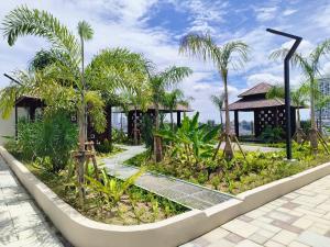 a garden with palm trees and a building at Wanz Barakah Homestay @ Bali residence in Melaka