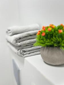 a pile of towels and flowers on a shelf at White Door Apartments in Haifa