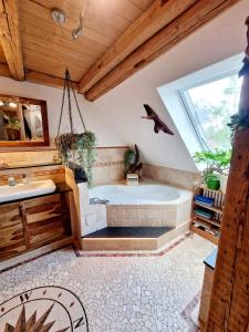 a large bathroom with a tub and a sink at Wood & Stone Lodge 2 in Donaueschingen