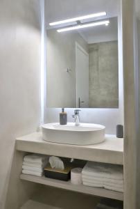 uma casa de banho com lavatório, espelho e toalhas em Villa Tropicana, luxury villa with pool by Sternes Properties em Sitia
