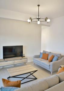 sala de estar con sofá y TV de pantalla plana en Villa Tropicana, luxury villa with pool by Sternes Properties, en Sitia