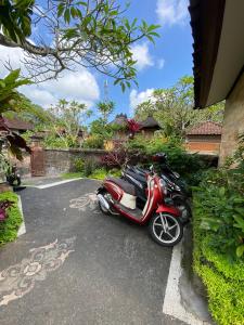 a red scooter parked in a parking lot at MALINI Homestay in Ubud