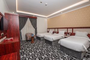 a hotel room with two beds and a television at فندق غالية احد in Al Madinah