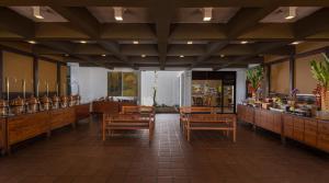 a restaurant with wooden tables and chairs in a room at Heritance Ayurveda - All Meals and Treatments in Bentota