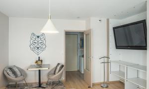 a living room with a tv and two chairs at Voltaire Wolf Suite - 5 min Hypercentre - Parking Privé in Troyes