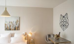 a bedroom with a bed and a table and a painting at Voltaire Wolf Suite - 5 min Hypercentre - Parking Privé in Troyes