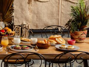 een tafel met borden en glazen melk bij Barba Boutique Hotel in Korçë