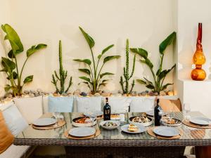 een tafel met borden met voedsel- en wijnflessen bij Barba Boutique Hotel in Korçë