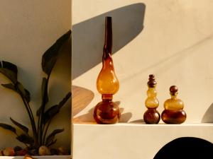 three glass bottles sitting on top of a shelf at Barba Boutique Hotel in Korçë