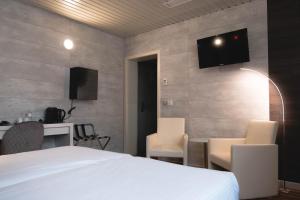 1 dormitorio con 1 cama, mesa y sillas en Hotel Richmond en Blankenberge