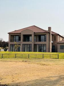 ein großes Haus mit einem Zaun davor in der Unterkunft Lerea Holiday Home in Vaal Marina