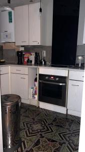 a kitchen with white cabinets and a black oven at Twilight in London