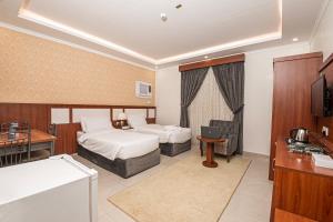 a hotel room with two beds and a television at فندق غالية احد in Al Madinah