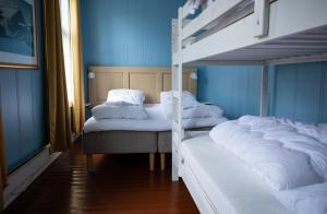 two bunk beds in a room with blue walls at Skanckegårdene AS in Røros