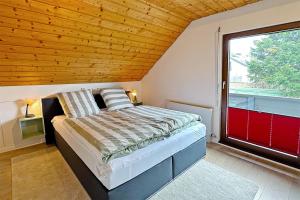 sypialnia z łóżkiem i dużym oknem w obiekcie Ferienwohnung Steinhart Kappel w mieście Lenzkirch