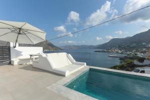 a villa with a swimming pool and an umbrella at Shape-Infinity in Kalymnos