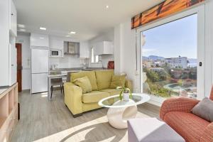 een woonkamer met een gele bank en een keuken bij Acapulco Playa 314 in Nerja