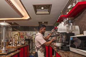 a man standing behind a counter in a coffee shop at فندق غالية احد in Al Madinah