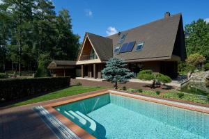 a house with a swimming pool in front of a house at Luxury villas Kaunas in Šlienava