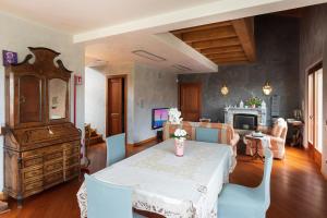 a dining room with a table and a living room at Villa Sasso Il Bianco Varese Lake in Comerio