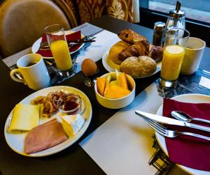einen Tisch mit 2 Frühstückstabletten und Orangensaft in der Unterkunft Hotel Richmond in Blankenberge