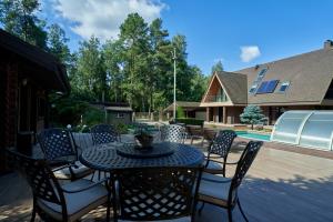 a patio with a table and chairs and a pool at Luxury villas Kaunas in Šlienava