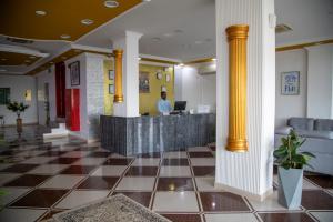 a lobby of a hotel with a man standing at a counter at DREAMLAND HOTEL APARTMENT NIZWA in Nizwa