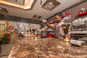 a bartender preparing a drink at a bar at فندق غالية احد in Al Madinah